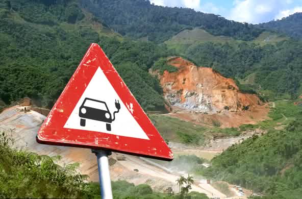 Photomontage : panneau de signalisation avec une voiture électrique devant une mine à ciel ouvert en Equateur