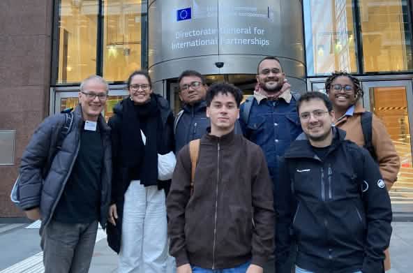 Photo de groupe de 7 personnes devant l’entrée du bâtiment de la Direction générale des partenariats internationaux à Bruxelles