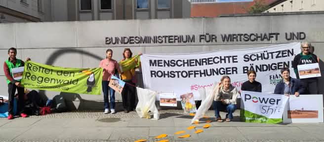 Des personnes tiennent des pancartes devant le mur du ministère fédéral allemand de l’Économie et de l’Énergie à Berlin