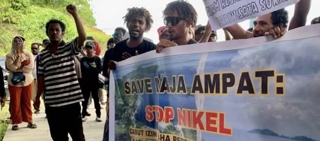 Des manifestants brandissant une banderole sur laquelle est écrit : « Sauvez Raja Ampat : Stop au nickel ».