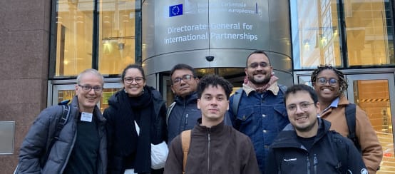 Photo de groupe de 7 personnes devant l’entrée du bâtiment de la Direction générale des partenariats internationaux à Bruxelles