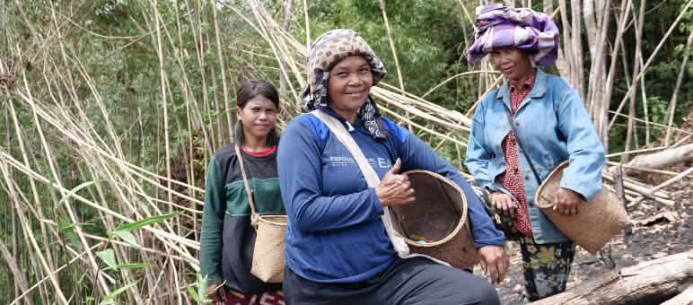 La forêt tropicale nous donne tout ce dont nous avons besoin ! Trois femmes du peuple Dayak avec des paniers pour la cueillette sourient à la caméra