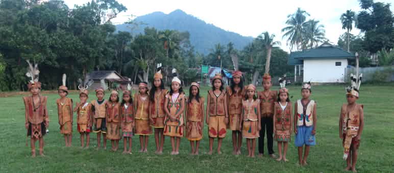 Les Dayak Tomun veulent préserver la forêt tropicale pour leurs enfants et petits-enfants dans les montagnes de Bornéo Enfants Dayak en habits traditionnels avec pour arrière plan les montagnes de Bornéo