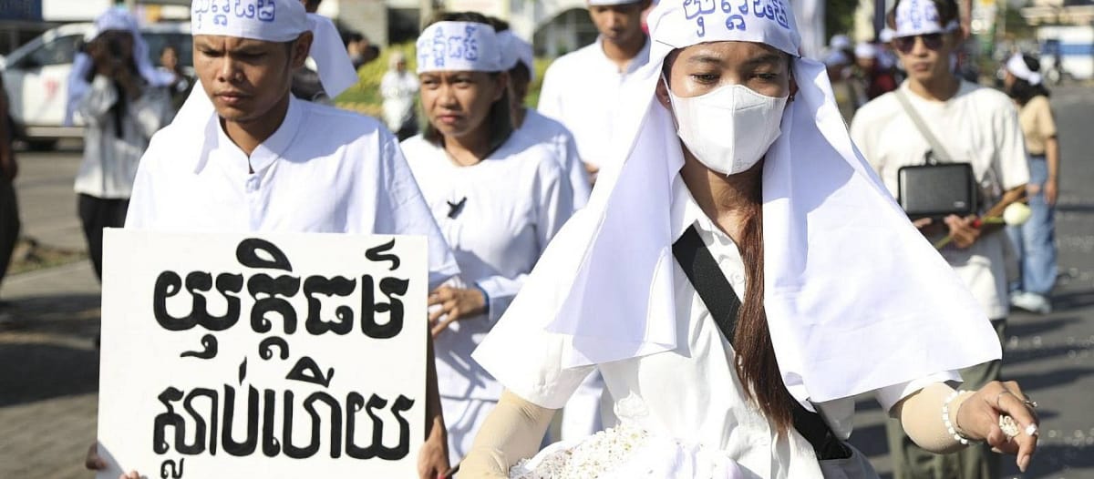 Habillés de blanc, des jeunes cambodgiens de l’organisation Mother Nature Cambodia défilent l’air grave