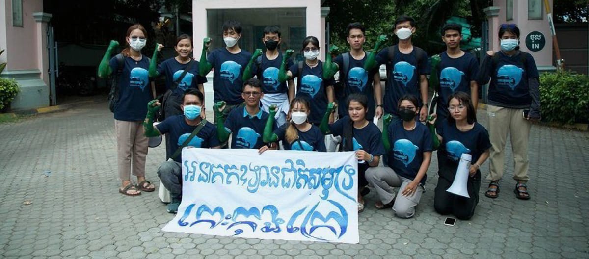 15 jeunes gens sont debout et agenouillés devant le bâtiment du ministère du Tourisme à Phnom Penh. Ils tiennent une bannière sur laquelle est écrit en cambodgien : "L’île de Koh Kong doit devenir un parc national marin"