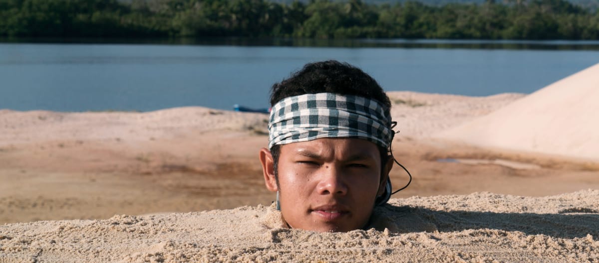 Activiste dont seule la tête dépasse hors du sable