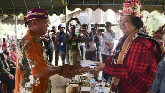 Willem Hengki remet une pétition à Siti Nurbaya, avec de nombreux photographes en arrière-plan