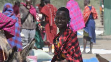 Femmes et hommes Massaï sur un marché, une femme regarde la caméra