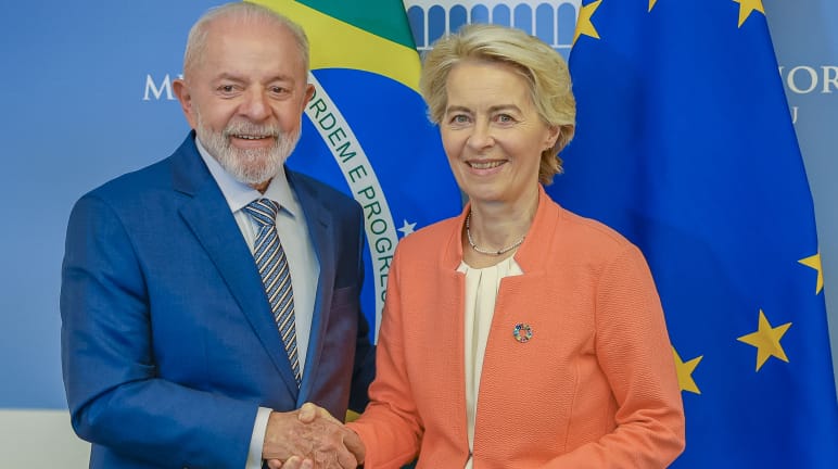 La présidente de la Commission européenne, Ursula von der Leyen, et le président du Brésil, Lula da Silva, se serrent la main devant les drapeaux brésiliens et européens