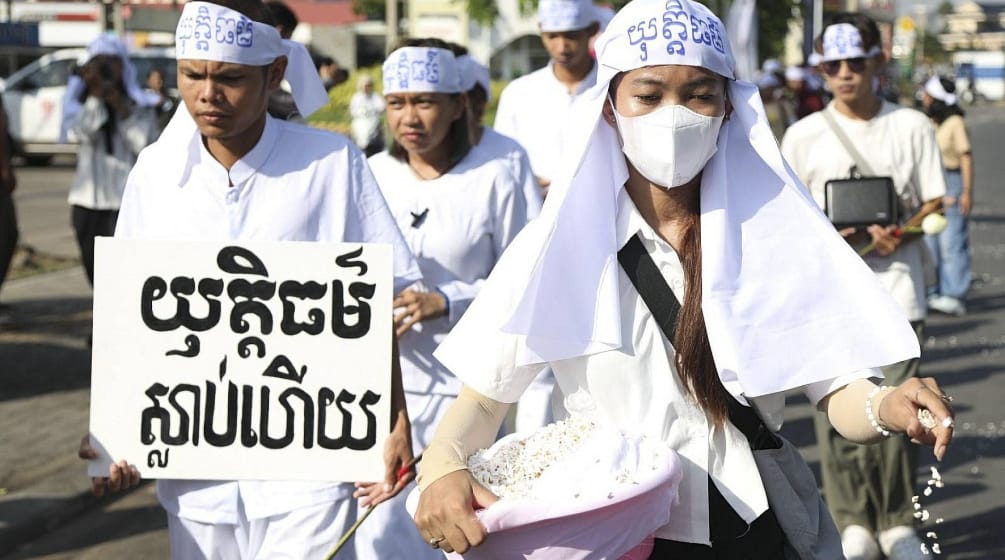 Habillés de blanc, des jeunes cambodgiens de l’organisation Mother Nature Cambodia défilent l’air grave