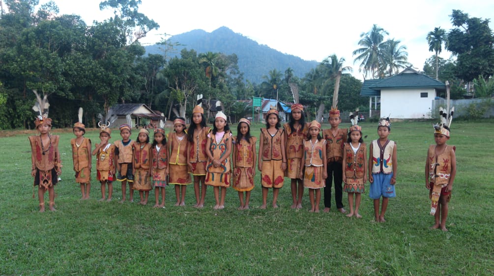 Enfants Dayak en habits traditionnels avec pour arrière plan les montagnes de Bornéo